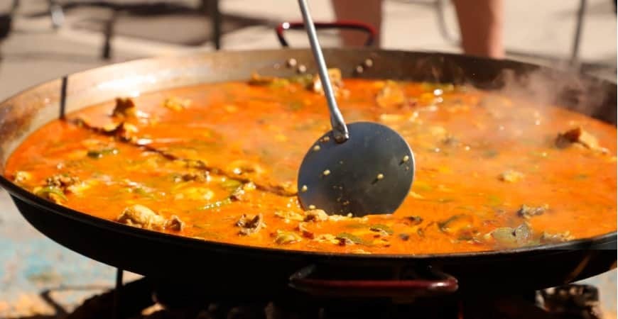In che modo l'altitudine e il clima influenzano la cottura della paella?